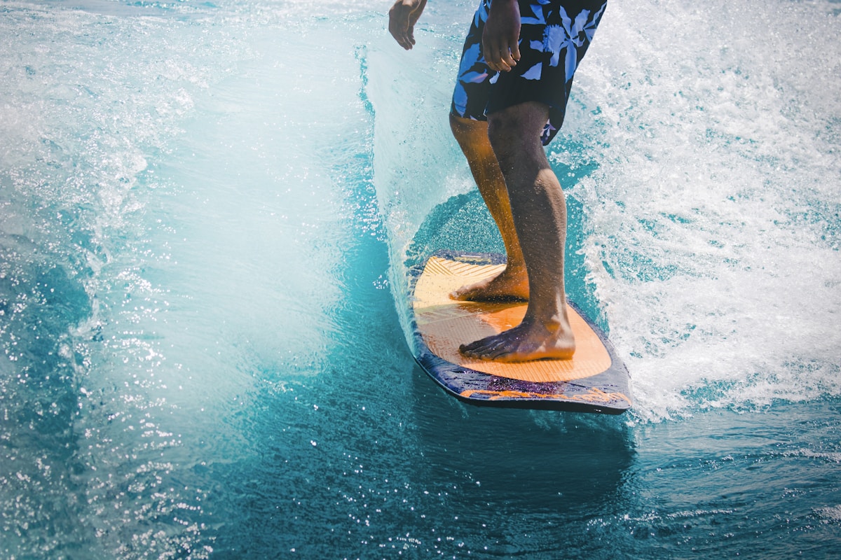 Surfer riding a wave on a surfboard in clear blue water