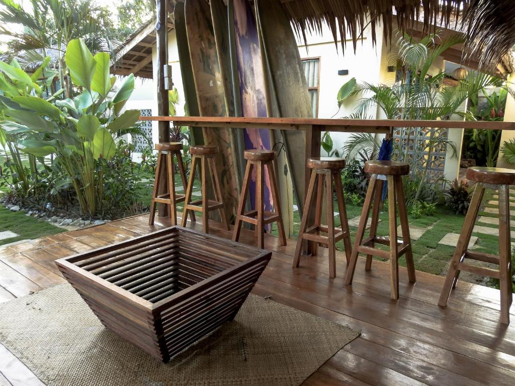 Bar and lounge area with surfboards, wooden stools, and thatched roof