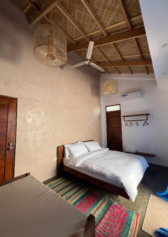 Private cabana room with traditional bamboo ceiling, queen bed, and colorful woven rug
