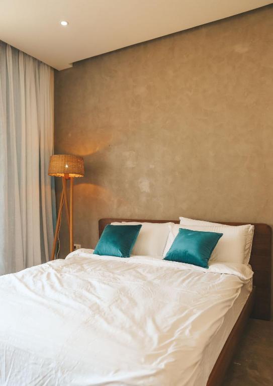 Single Fin modern room with white bedding and teal accent pillows
